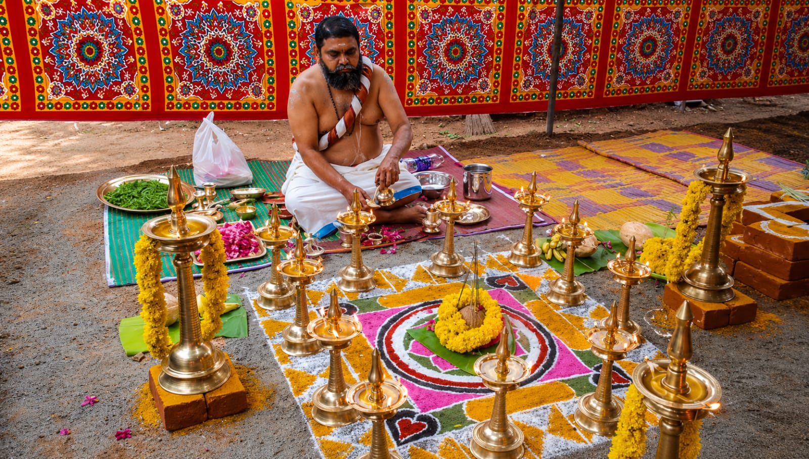 Traditional Vedic ritual with brass lamps and a ceremonial kalam